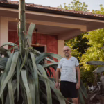 Francesco accanto all'Agave in fioritura. Notare le foglie avvizzite
